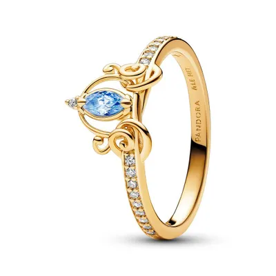 A close-up studio shot of a gold ring with a blue gemstone and clear accent stones.