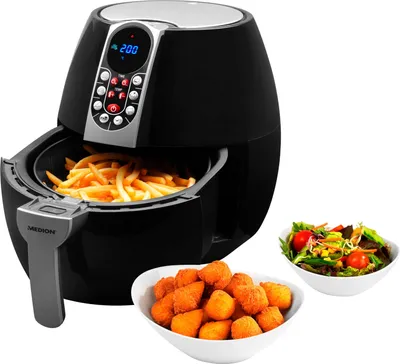 A black air fryer with a digital display and a basket filled with french fries. Two bowls of food, one with fried nuggets and another with a salad, are placed next to it.