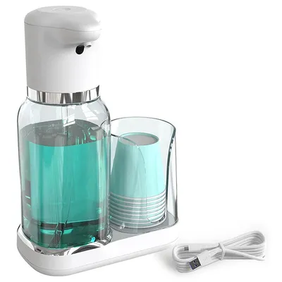A white automatic soap dispenser with a clear glass reservoir filled with blue liquid, a cup holder with blue cups, and a USB charging cable on a white base.