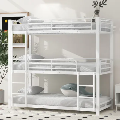 A white triple bunk bed with mattresses and pillows in a room with a patterned rug and a plant.