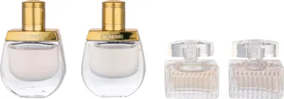 Four miniature perfume bottles are arranged in two pairs against a white background.