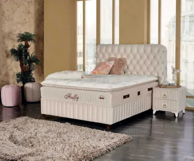A bedroom scene featuring a bed, nightstand, and decorative items.