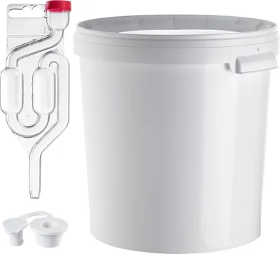 A white plastic fermentation bucket with a red-capped airlock and two white stoppers.