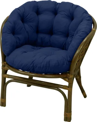 A navy blue cushion on a brown rattan chair.