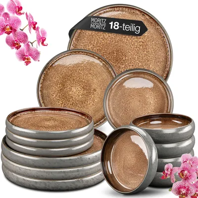 A collection of ceramic plates and bowls with a speckled brown interior and gray exterior, arranged on a white background with pink orchids.