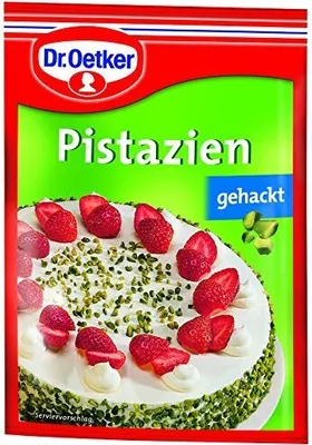 A package of chopped pistachios with a picture of a cake decorated with pistachios and strawberries.