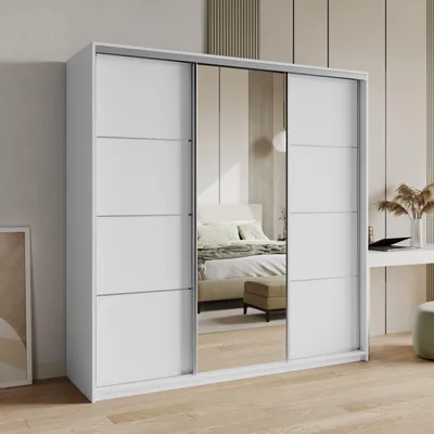 A white sliding door wardrobe with mirrored doors, reflecting a bedroom interior.