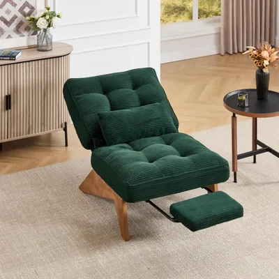 A green corduroy recliner chair with an ottoman is placed on a rug in a living room, next to a wooden cabinet and a small round table.
