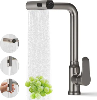 A modern kitchen faucet with water flowing, washing a bunch of grapes.