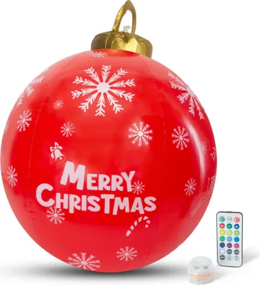 A large, inflatable red Christmas ornament with white snowflake and text decorations, shown with a remote control and a small light.