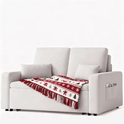 A cream-colored sofa with a red and white patterned throw blanket draped over it.
