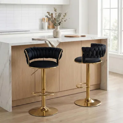 Two black bar stools with gold bases are shown in a modern kitchen setting.