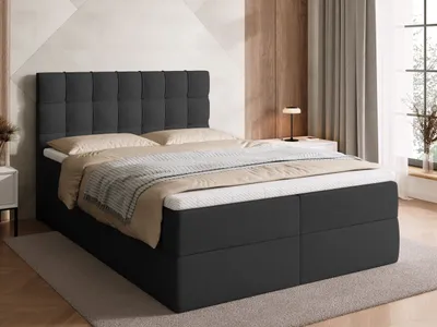 A bed with a headboard and mattress in a bedroom setting.