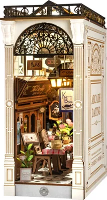 A miniature diorama of a Parisian-style arcade dating scene, featuring a cafe and bookshop.