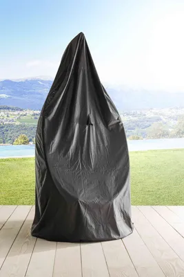 A hanging chair covered by a protective cover, placed on a wooden deck with a scenic background of mountains and a body of water.