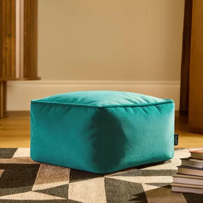 Immagine prodotto di Pouf imbottito in velluto blu-verde, prodotto in Germania. Pouf in velluto morbido, ideale come poggiapiedi per il soggiorno o la camera da letto
