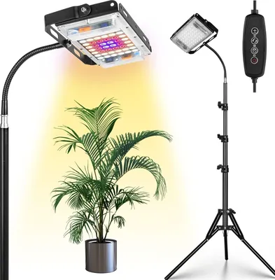 A plant grow light with a tripod stand and a remote control, illuminating a potted plant.