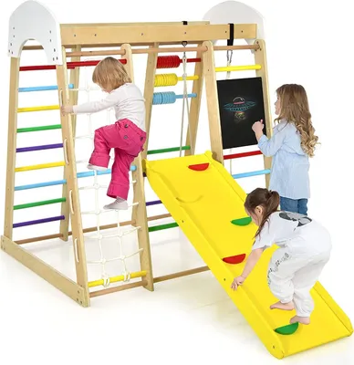 Children playing on a wooden indoor playground with a slide and climbing elements.