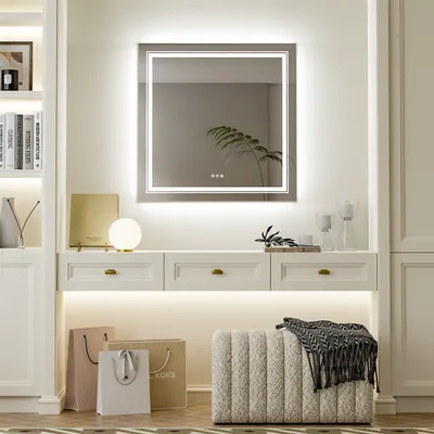 A well-lit vanity area with a large LED mirror, drawers, and decorative items.