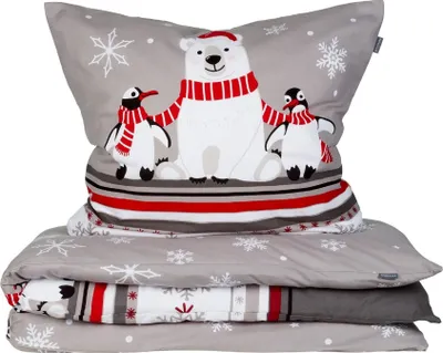 A stack of folded bedding with a winter-themed print featuring a polar bear and penguins.