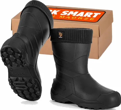 A pair of black rubber boots with a knitted cuff and a cardboard box in the background.