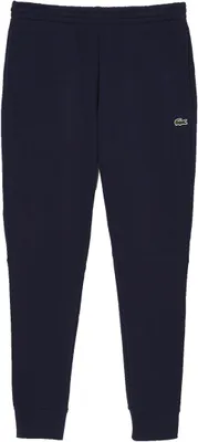 A pair of navy blue sweatpants with a small green crocodile logo on the upper right leg.