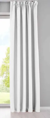 A white curtain hanging in front of a window with greenery visible outside.
