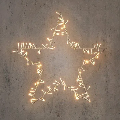 A star-shaped string of lights is mounted on a textured wall.