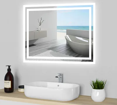 A modern bathroom sink with a mirror reflecting a serene beach scene.