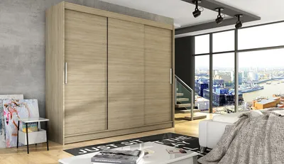 A modern bedroom with a large sliding door wardrobe, a large window with a city view, and a sofa.