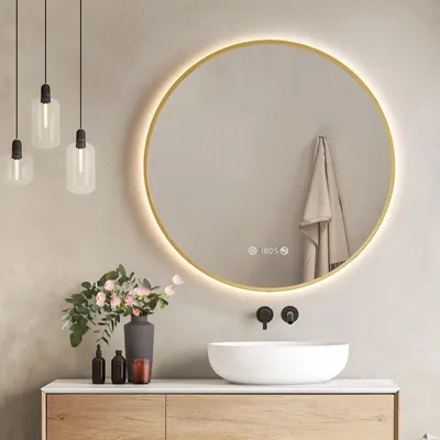 A modern bathroom vanity with a round LED mirror, sink, and decorative items.