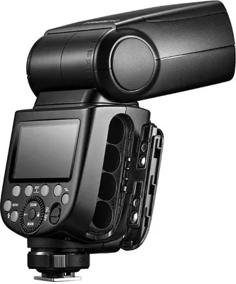 A black camera flash unit with its battery compartment open, showing four AA battery slots.