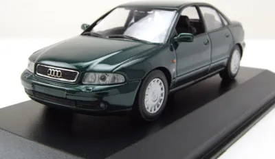 A dark green Audi A4 model car is displayed on a black base.