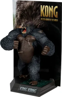 A King Kong figurine on a display stand with a backdrop.