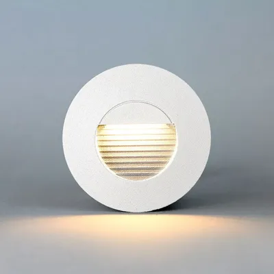 A white, circular LED stair light is shown against a light gray background.