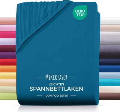 A teal colored fitted sheet is shown folded, with a stack of other colored fitted sheets visible in the background.