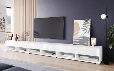 A modern living room with a large TV mounted on a wall above a long white media console.