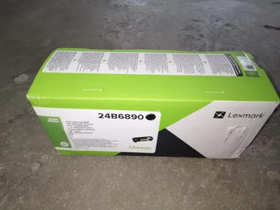 A product box for a Lexmark toner cartridge is placed on a concrete floor.