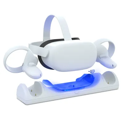 A white Oculus Quest 2 VR headset and controllers are shown resting on a white charging dock with blue LED lights.