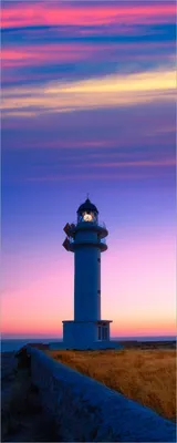 Produktbild von Wallario selbstklebendes Poster - Leuchtturm am Abend auf den Balearen Malerischer Himmel, Größe: 80 x 200 cm