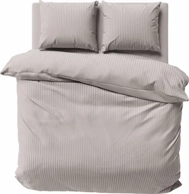 A neatly made bed with beige striped bedding.