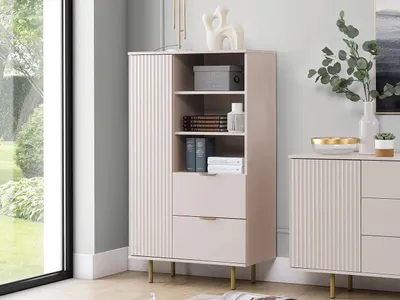 A modern living room with a light pink cabinet and a window with greenery outside.