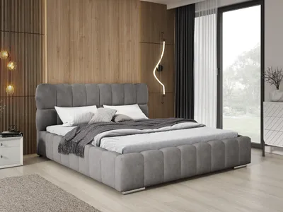 A modern bedroom with a large upholstered bed as the focal point.