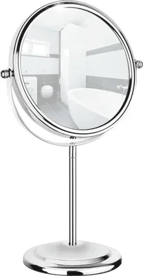 A silver-colored double-sided vanity mirror with a stand, reflecting a bathroom interior.