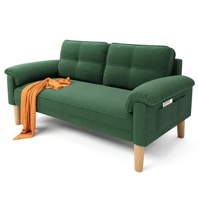 A green sofa with an orange throw blanket draped over the armrest, set against a white background.