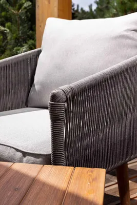 A close-up view of an outdoor chair and a wooden table.