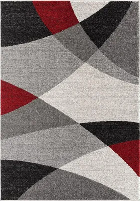 A flat lay of a geometric rug with abstract shapes in red, black, and various shades of gray.