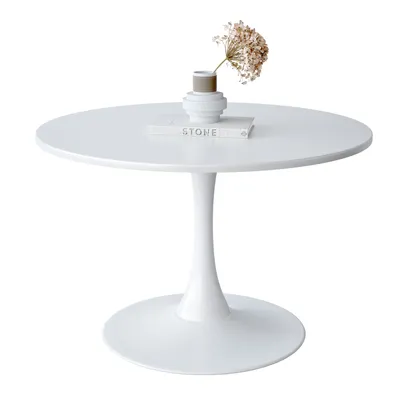 A white round dining table with a decorative vase and dried flowers on top.