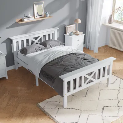 A white bed in a bedroom setting.