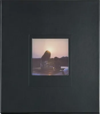 A black photo album with a small inset picture of two people at sunset.
